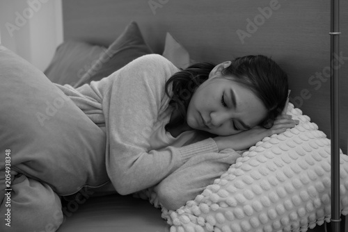 Konstfotografi Soft insomnia woman lying on couch curled with textured pillow and blanket conve
