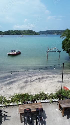 Aerial view of beautiful beach in Sabang Island in Aceh, Indonesia. Drone reveal shot of a woman walking to the beach from resort and beach villa. Summer vacations concept in tropical resort