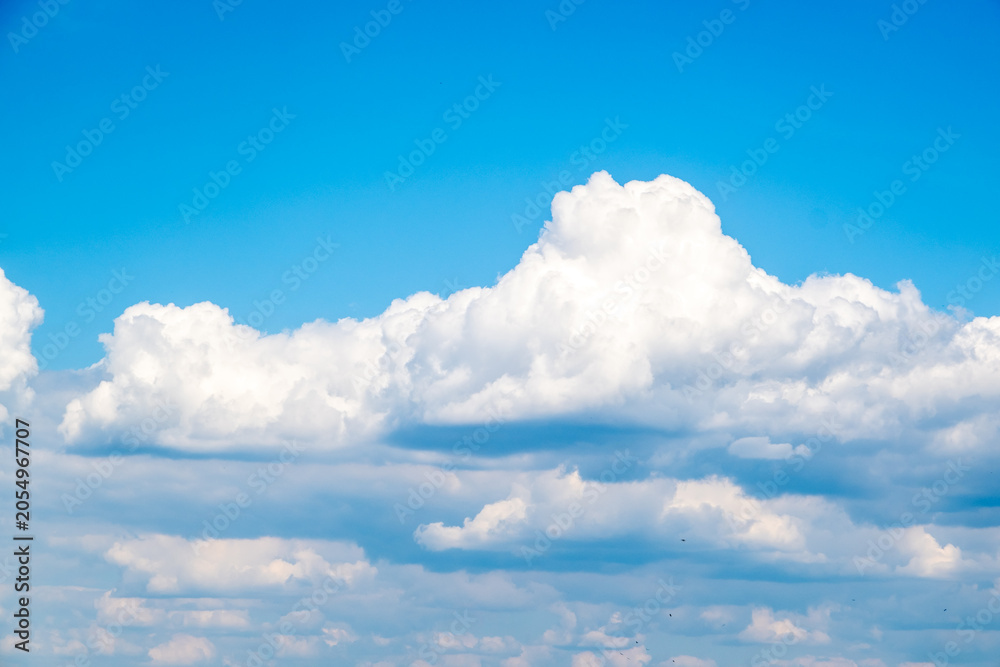 Fototapeta premium Bright Blue Sky With Large Fluffy Cumulus Clouds Over Calm Horizon