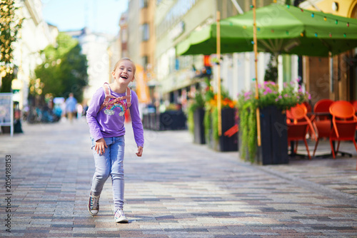 Cuadro en lienzo Full length portrait of a smiling young girl standing on a pedestrian street in