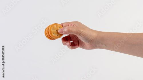 Peanut butter filled crackers, a snack in hand, on white background. 