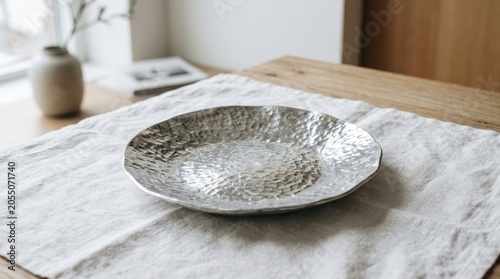 Hammered Silver Plate with Textured Surface on a Linen Tablecloth