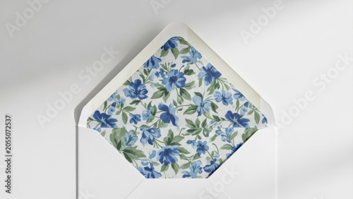 Elegant open white envelope with blue floral pattern lining on a minimalist white surface Wallpaper Background image
