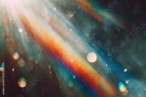Abstract light leak overlay with rainbow prism flares and film grain texture, scattered dust specks and bokeh circles perfect for creative overlay and post production concept