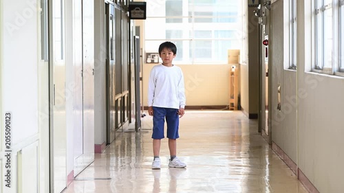 光の差し込む学校の廊下で元気に踊る男子小学生