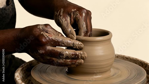 Potter shaping clay pot on wheel in studio for artistic craftsmanship