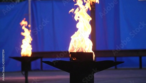 Two torches blaze with vibrant flames against a deep blue background