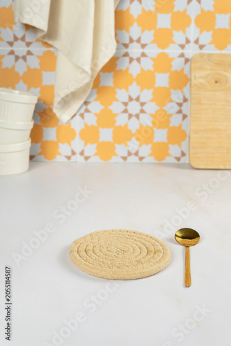 Kitchen counter with a round woven trivet and a golden spoon