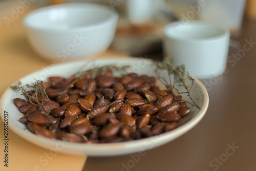 Obraz na plátne Close up of roasted almonds with fresh thyme, extra virgin olive oil, and spices