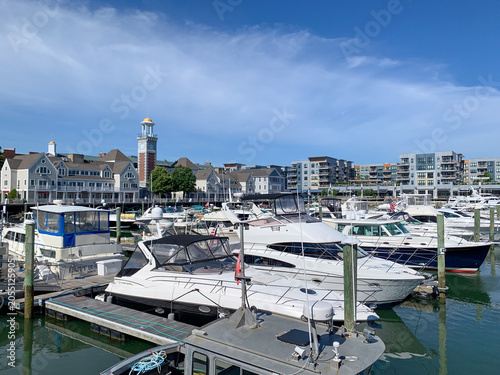 Recreational boats and yachts moored at Marina Bay in Quincy, Massachusetts, with modern waterfront residences and Boston Harbor views on a clear summer day.