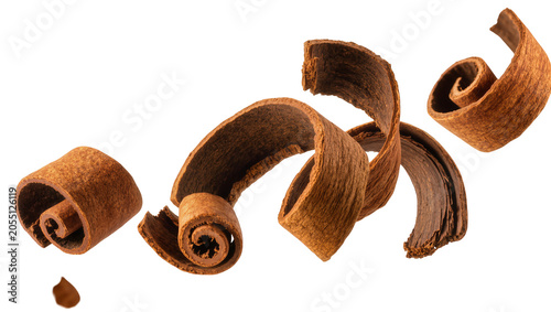 Fotografie Isolated cinnamon quills and broken pieces floating, aromatic spice for baking and cooking