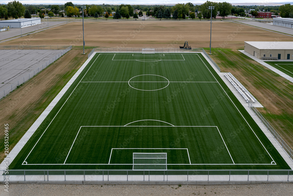 Fototapeta premium Daytime green soccer field at complex