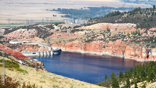 Bighorn Dam spans a narrow canyon above deep blue reservoir waters, highlighting water management infrastructure amid the rugged landscapes of the American West.