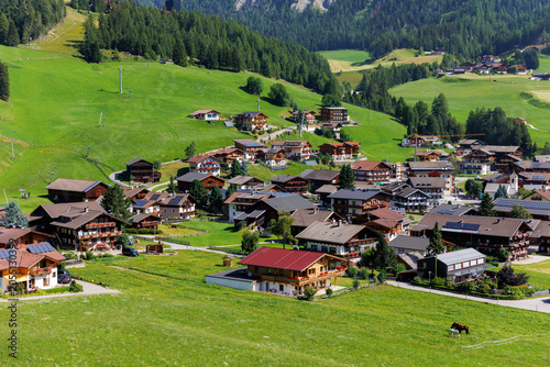 Foto Scenic aerial alpine view austrian mountain village Kals am Grossglockner valley green rural farmland meadow horse pasture background