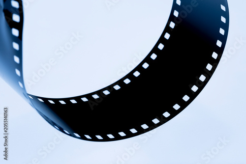 Unrolling 35mm film reel for processing or developing, symbolizing analog photography and vintage cinema technology