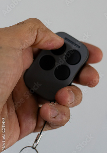 Close up of a mans hand pressing buttons on a black television remote control