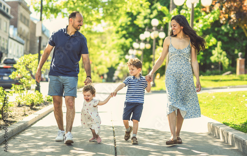 family of four people playing with childs outdoors in park place