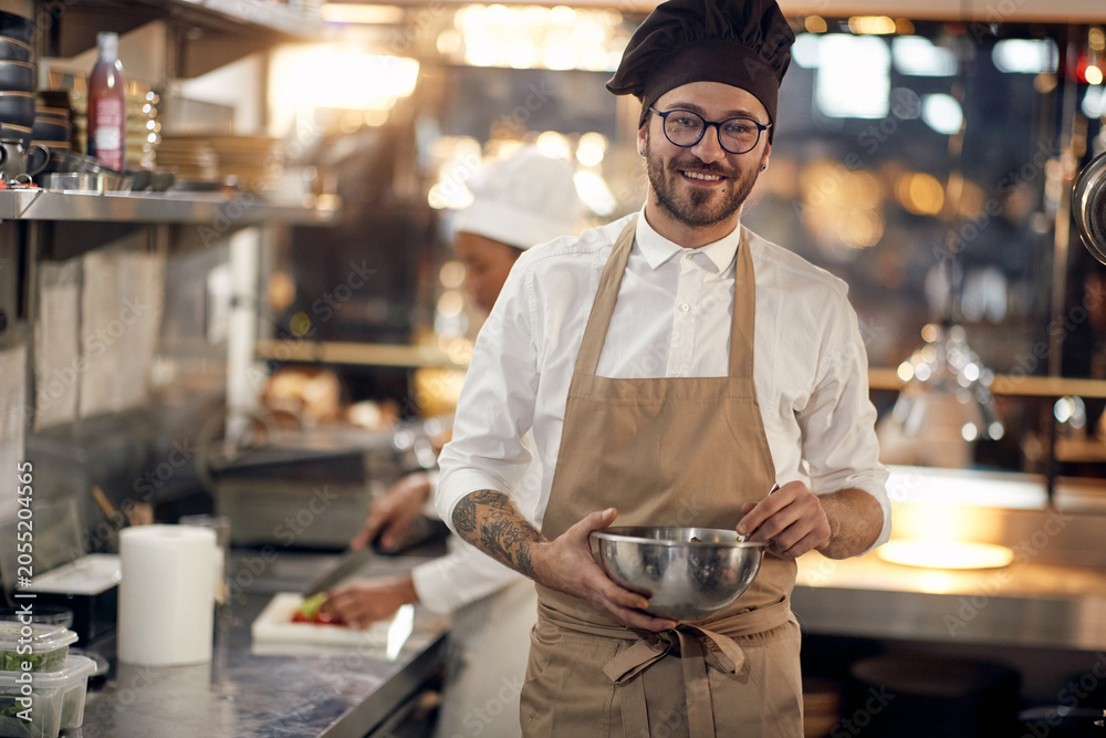 Fototapeta premium handsome chef . Cook in Professional Modern kitchen, restaurant concept