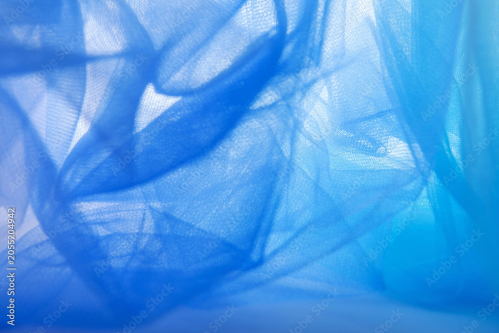 Obraz premium Background, abstract blue mesh fabric creates soft wavy folds.