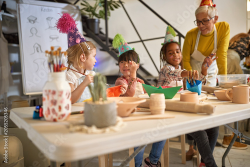 Smiling kids on creative workshop celebrate together a birthday.  Creative  hobby  workshop  concept