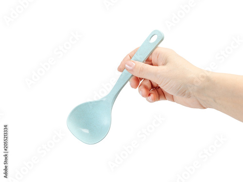 Woman's hand holding a spoon on the white background.
