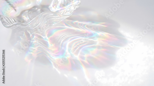 Iridescent clear glass bowl casting rainbow caustics on white table