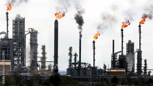 Black smoke and flames rising from oil refinery industrial pipes