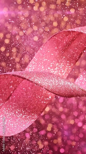 Close-Up of Sparkling Pink Ribbon with Glittering Edges Against a Festive Golden Bokeh Background