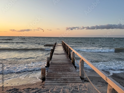 waves in the evening at the long wooden pier by the sea