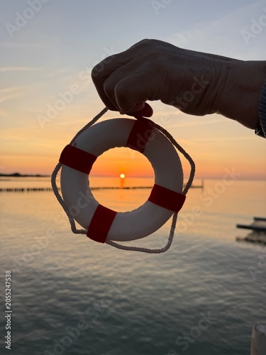 hand holding life belt in sunset
