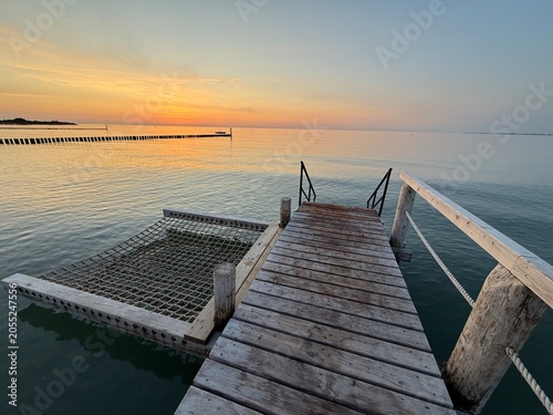 wooden pier with a comfortable hammock at sunset