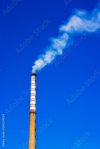 Industrial Power Plant Chimneys Emitting Smoke Against Blue Sky