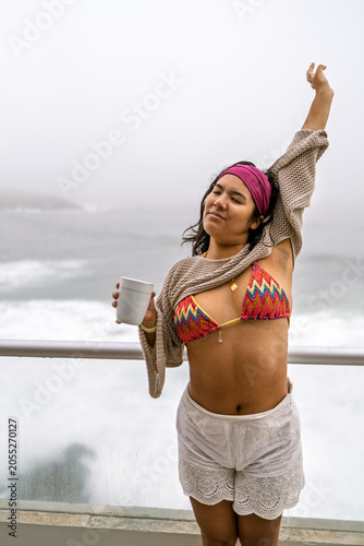 Slika na platnu Young woman stretching on oceanfront balcony enjoying serenity