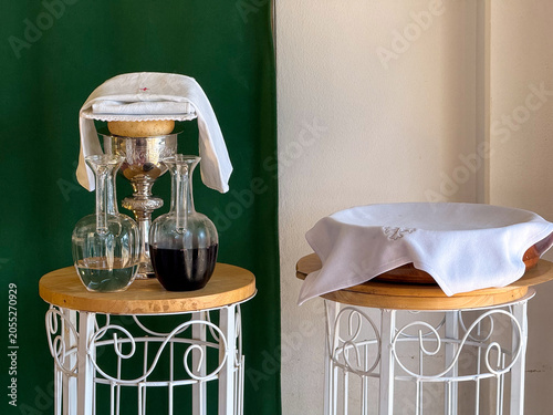Photos Communion chalice, wine cruets, and host on church table