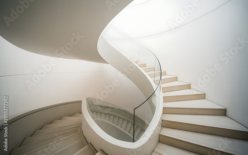 A white spiral staircase with a glass railing in a bright interior isolated on a transparent background