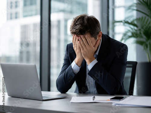 Schilderij op canvas Stressed Businessman Covering Face in Modern Office
