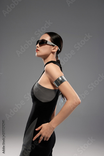 Futuristic Fashion Woman in Black Dress and Visor Sunglasses