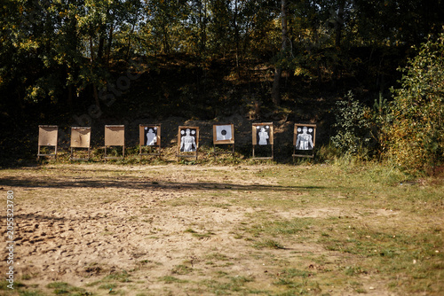 Obraz na płótnie Outdoor shooting range with multiple targets lined up against a dense woodland backdrop
