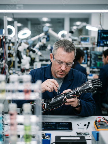 Robotics engineer assembling advanced prosthetic bionic arm in laboratory