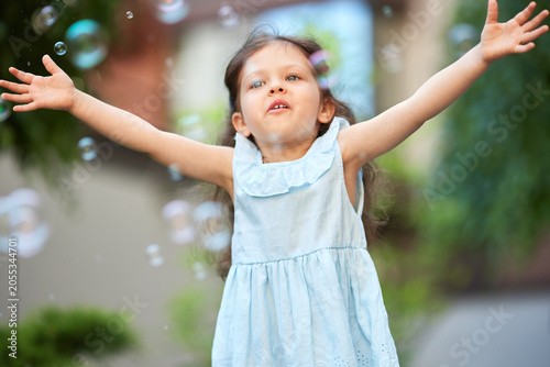 Photography Happy little child playing with soap bubbles in outdoors