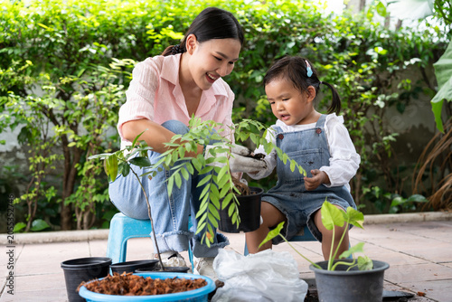 Asian family of three generations gardening happily outdoors, symbolizing bonding, teamwork, and sustainable lifestyle with plants, soil, and cheerful mood in bright natural environment and positivity