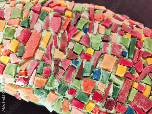 Close-up of a colorful mosaic made of ceramic fragments. Abstract texture, decorative art, handmade craftsmanship, detailed mosaic pattern.