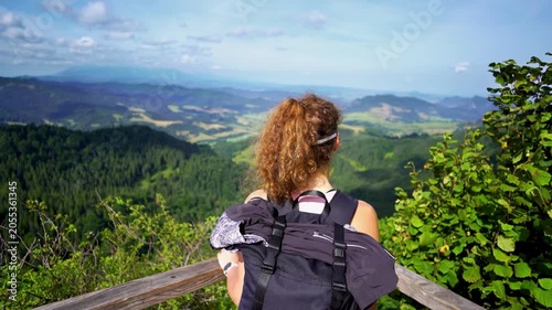 A young hiker admiring the stunning view of hills mountains and forests from a viewpoint on the trail