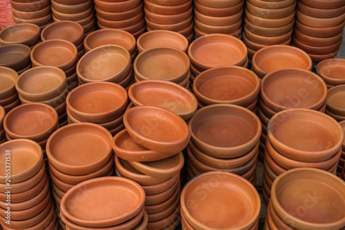 Hand-made ceramic items - plates and dishes - are displayed on the counter.ъ