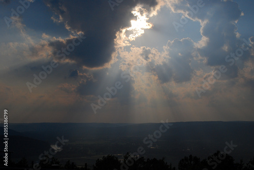 god rays stream from clouds towards the ground 