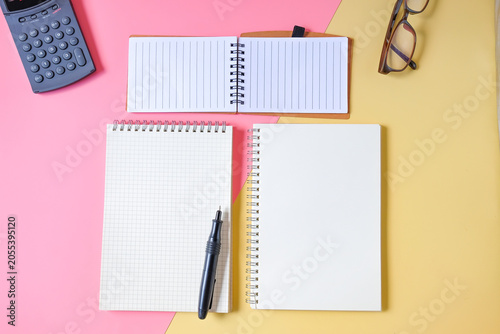 Different notebooks lie on two tone background.