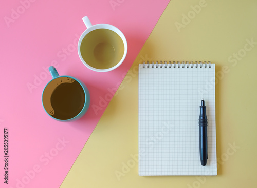 Cup of tea and coffee with book note on  two tone background.