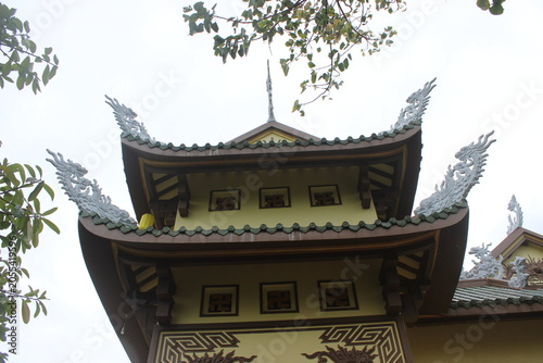 Tiered pagoda roof with upturned eaves adorned with mythical creatures and foliage.