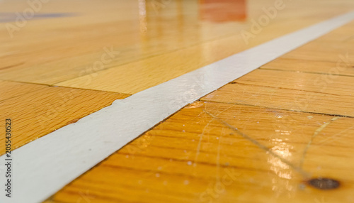 A white boundary line cuts the varnished court like a quiet portal into the next play