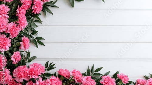 Pink carnations and greenery frame a white wooden plank background